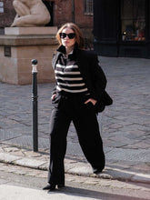 A lady wears a wool-striped vest.